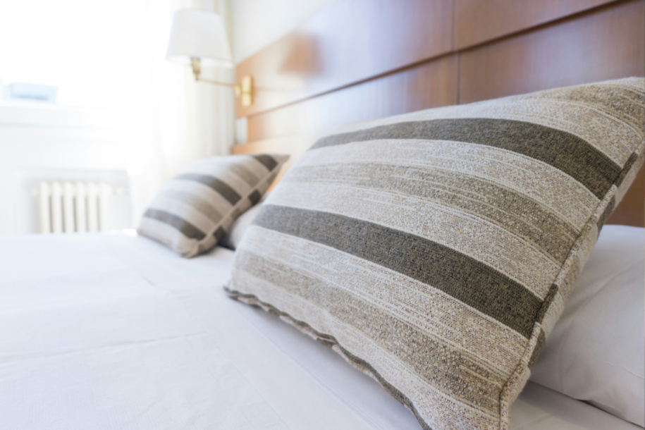Hotelbed waar twee kussens op het bed liggen